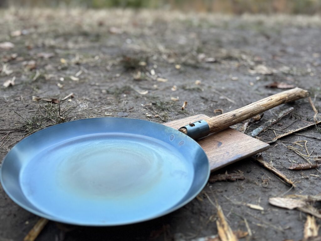 枝の柄を付けた焚き火フライパン